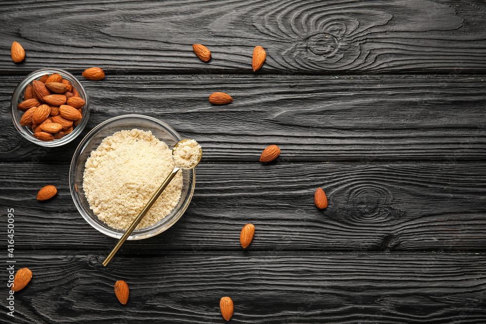 Bowl and spoon with almond flour on dark wooden background Bowl and spoon with almond flour on dark wooden background