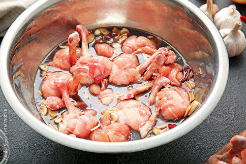 Bowl with raw chicken lollipops on dark background, closeup