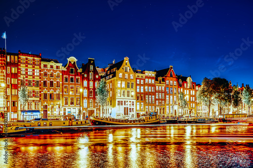 Famous Amstel river and night view of beautiful Amsterdam city. Netherlands