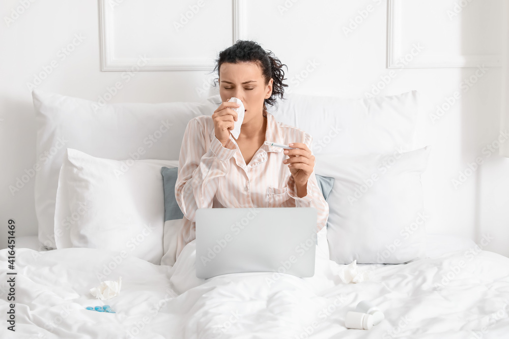 Sick young woman with laptop working at home Sick young woman with laptop working at home