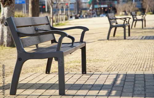 A park on a sunny day lined with benches © aozora