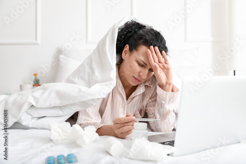 Sick young woman with lapto...