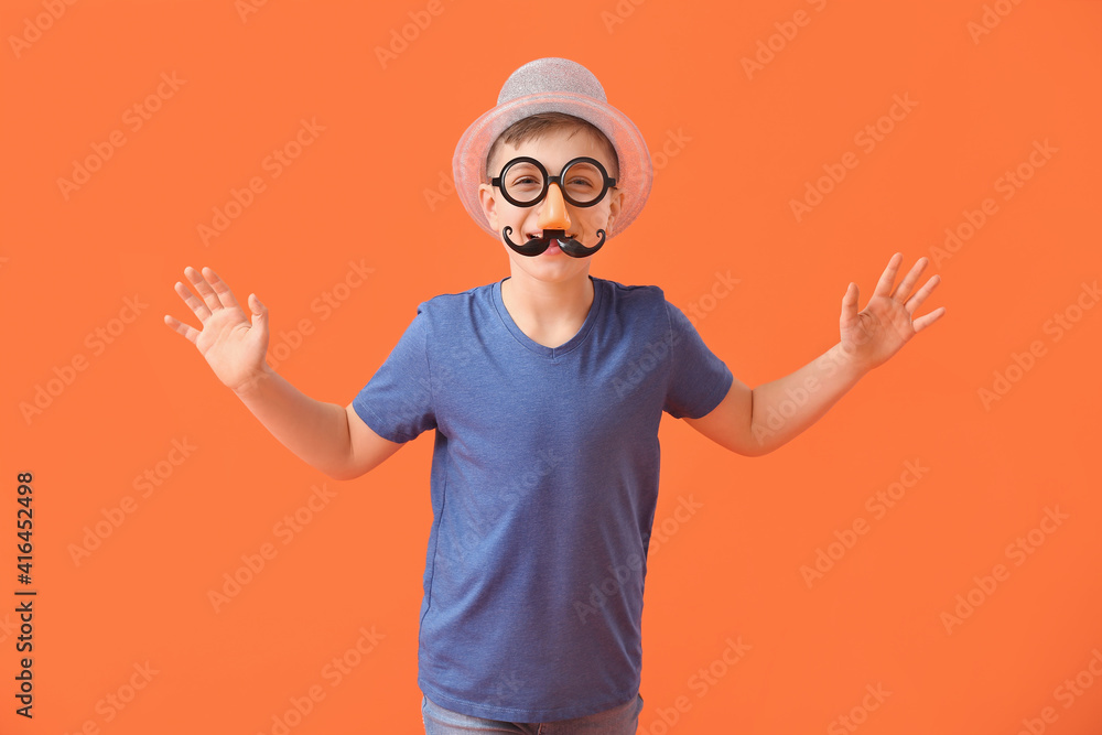 Naklejka premium Little boy in funny disguise on color background. April Fools Day celebration