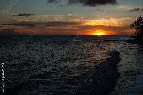Flaming orange sunset over calm ocean beach