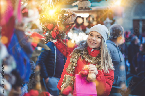 Positive female with handmade Christmas gifts on the street market. High quality photo