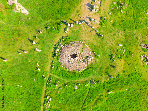 Large stones in a field with round holes in Karahunj - Armenian Stonehenge, Zorats Karer, Armenia top view photo