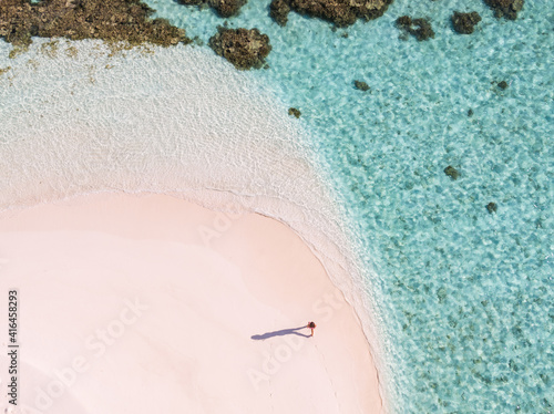 Overhead view of woman walking on a beach, Maldives photo