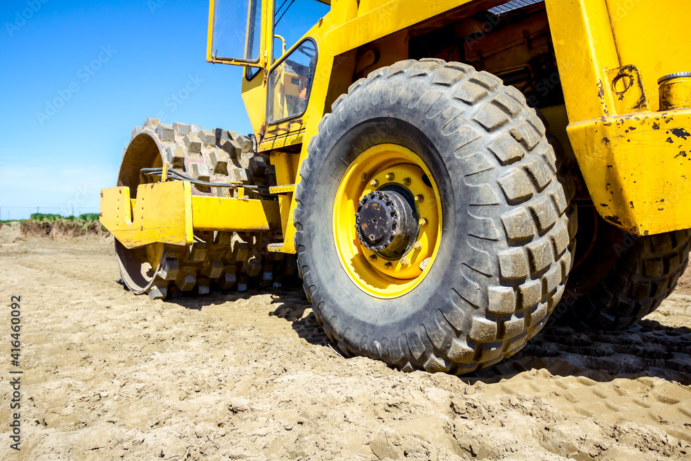 Road roller with spikes is working at construction site