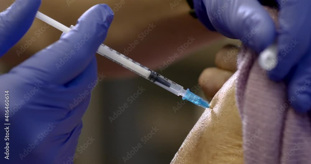 Uvotizen Injection The nurse is holding a syringe making the injection to the senior ...