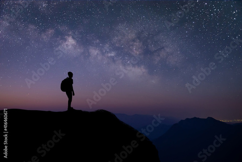 Silhouette of young traveler and backpacker watched the star and milky way on top of the mountain alone before sunrise. He is happy to be with herself and stay with nature at twilight time.