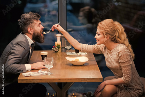Date of family couple in romantic restaurant. Proposal and anniversary. Valentines day with sexy couple of woman and bearded man.