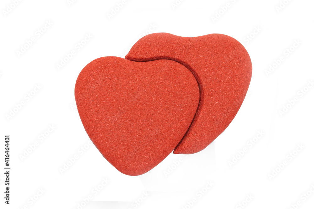 Two red hearts made from kinetic sand isolated on white background. Valentine's Day symbol