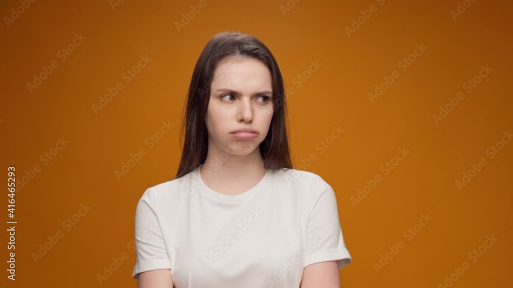 Bored and irritated young woman tired of waiting, against yellow background Bored and irritated young woman tired of waiting, against yellow background