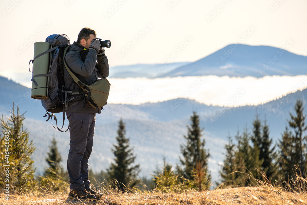 Photographer with hiking backpack taking pictures of nature with digital photo camera. Photographer with hiking backpack taking pictures of nature with digital photo camera.