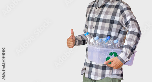 Hand of a man carrying a box of plastic bottle with recycle sign show thumbs up standing on white background. environment day, sustainable lifestyle and zero waste concept.