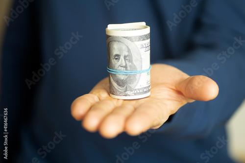 A man holds cash American dollars in his hand. Money, business, profit and livelihood concept.Selective focus