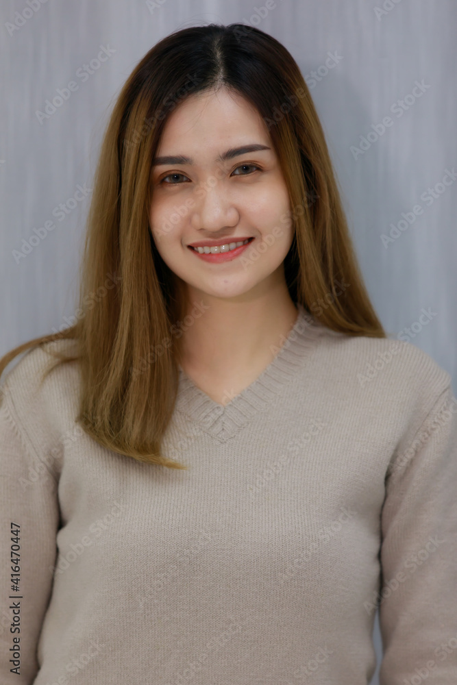 Smiling asian beautiful woman Standing wearing a Gray dress in the bedroom behind a curtain. Female asia smlie in gray background. Smiling asian beautiful woman Standing wearing a Gray dress in the bedroom behind a curtain. Female asia smlie in gray background.
