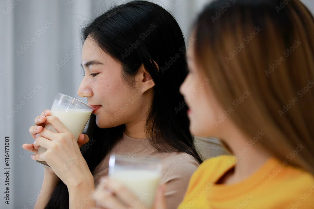 Smiling Two Asian young womenDrink milk in a glass lovely couple on white bed and happy. Funny women Before going to bed together on cozy. Concept In love homosexual lesbian lgbt, lgbtq, lgbtq+. Smiling Two Asian young womenDrink milk in a glass lovely couple on white bed and happy. Funny women Before going to bed together on cozy. Concept In love homosexual lesbian lgbt, lgbtq, lgbtq+.