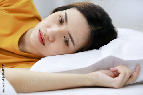 Angry bored. Asian beautiful woman wearing a Orange dress Touchy girlfriend on the bed in the bedroom at home. Concept Angry bore woman Not satisfied in love homosexual lesbian lgbt, lgbtq, lgbtq+.