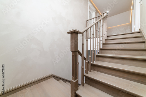 A general view of the handmade wooden oak staircase in the house. Light matte scrawl of wood