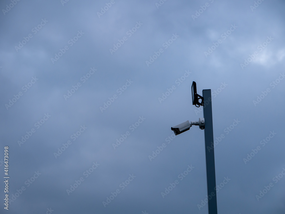 Projector and CCTV camera in gray sky background