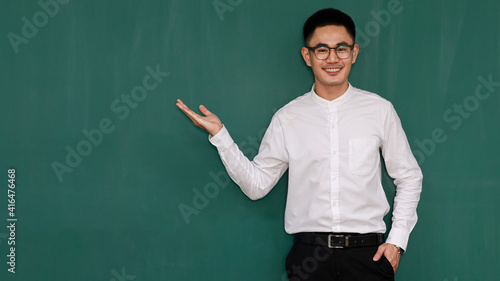 Portrait of young and handsome Asian man wearing eyeglasses and casual business clothes, white shirt and black trousers, pose in gestures of advertising and present somethings with self-confidence