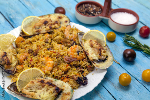 Italian food concept, paelias with mussels and seafood, Risotto with seafood, mussels, octopuses, squid. Serving dishes in a white plate. photo