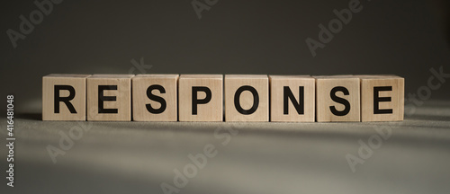 A wooden blocks with the word RESPONSE written on it on a gray background.