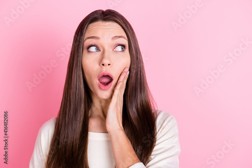 Portrait of impressed lady arm on cheek open mouth look interested empty space isolated on pink color background