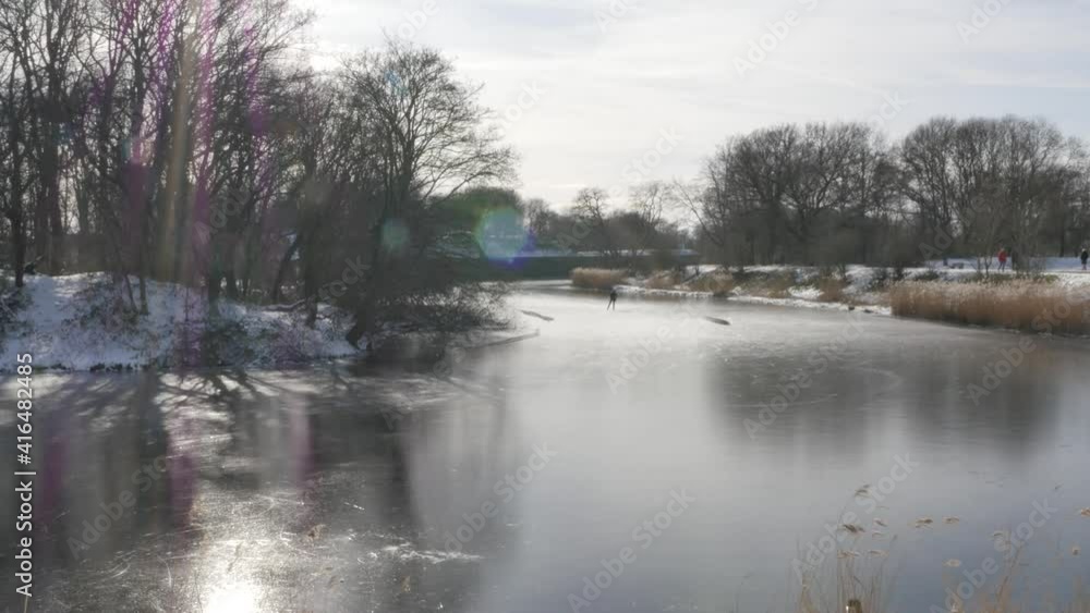Netherlands - 14 februari 2021, Naarden: Man skating on ice in beautiful nature Netherlands - 14 februari 2021, Naarden: Man skating on ice in beautiful nature