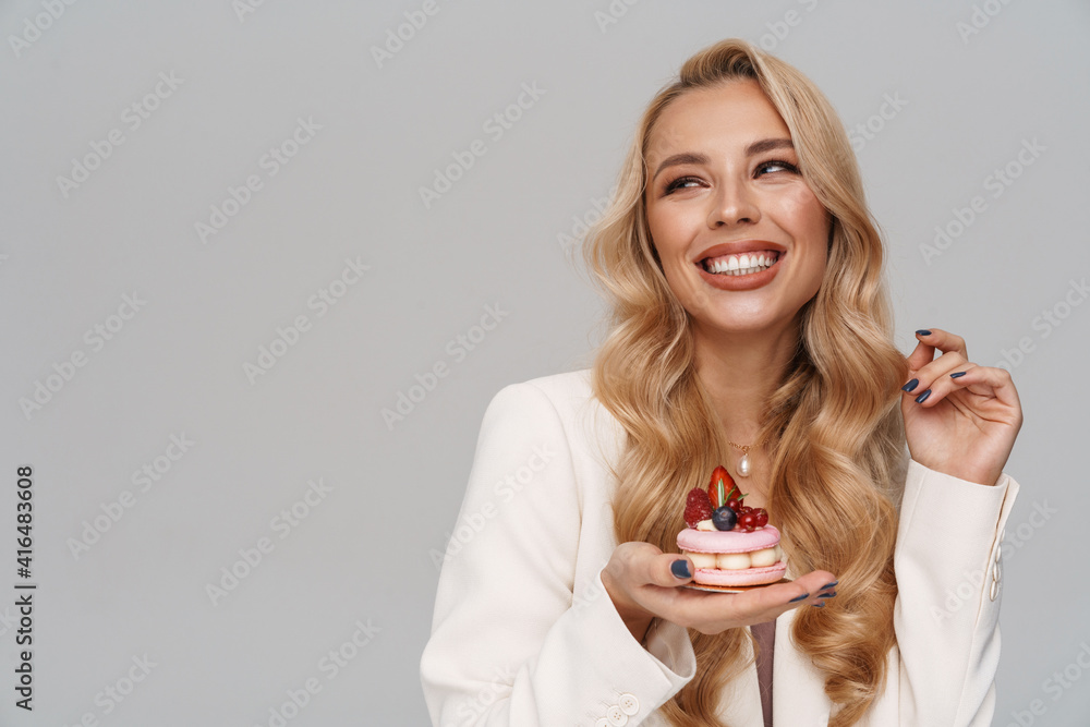 Happy gorgeous woman smiling while posing with cake
