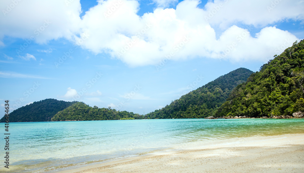 Summer vacation holiday with turquoise ocean water and blue sky with clouds in sunny and mountain background