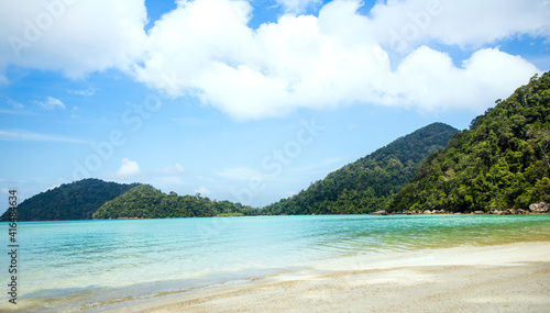 Summer vacation holiday with turquoise ocean water and blue sky with clouds in sunny and mountain background © SASITHORN