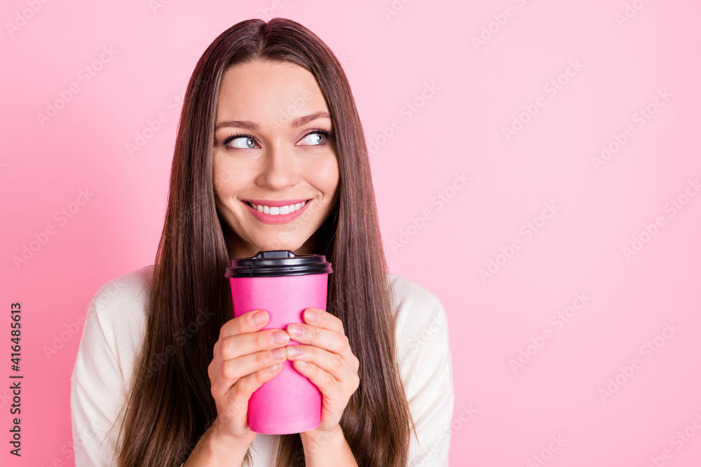 Portrait of attractive cheerful lady arms hold coffee look interested empty space isolated on pink color background Portrait of attractive cheerful lady arms hold coffee look interested empty space isolated on pink color background