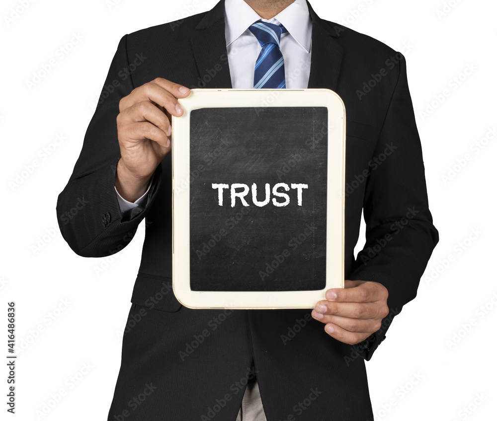 A Businessman holding slate mini blackboard with message Trust A Businessman holding slate mini blackboard with message Trust