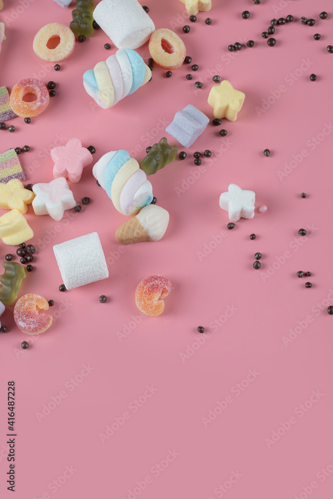 Marshmallow and jelly beans mix on the pink background Marshmallow and jelly beans mix on the pink background