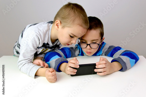 Two little boys playing a game on the smartphone