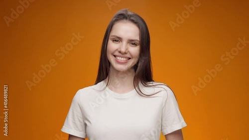 Smiling woman nods her head and says 'yes', approving