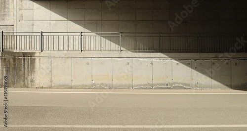 Obraz na płótnie Concrete block wall of an underpass with a footpath and a railing in the middle