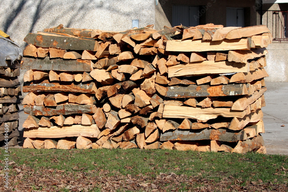 New fresh neatly stacked firewood left in family house driveway next to