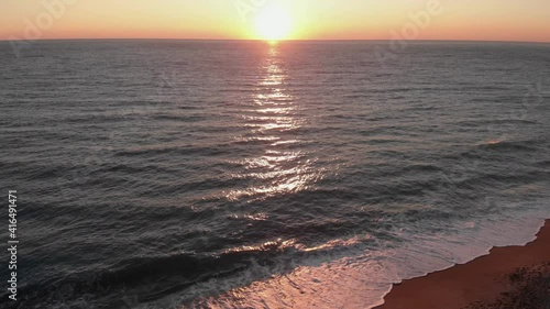 Beach sunset. Aerial drone view of pink sindown over ocean photo