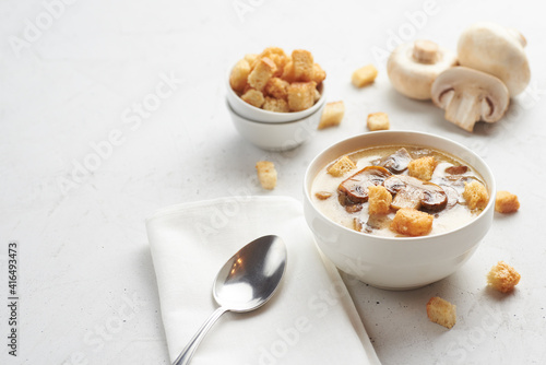 Tasty mushrooms soup with croutons on a white table. Healthy diet concept.