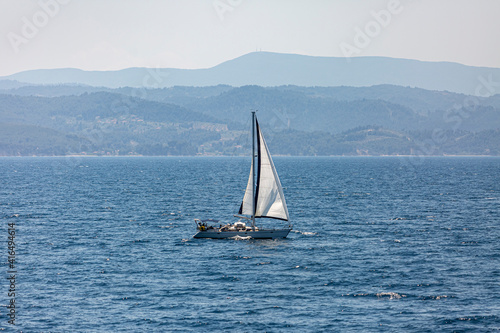Papier peint A single white sailing boat in the open sea.