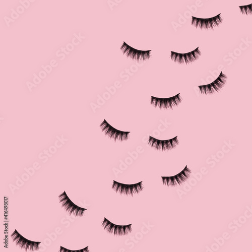 Creative pattern made with false eyelashes on pastel pink background. Retro style aesthetic. Trendy and fashion beauty makeup idea.