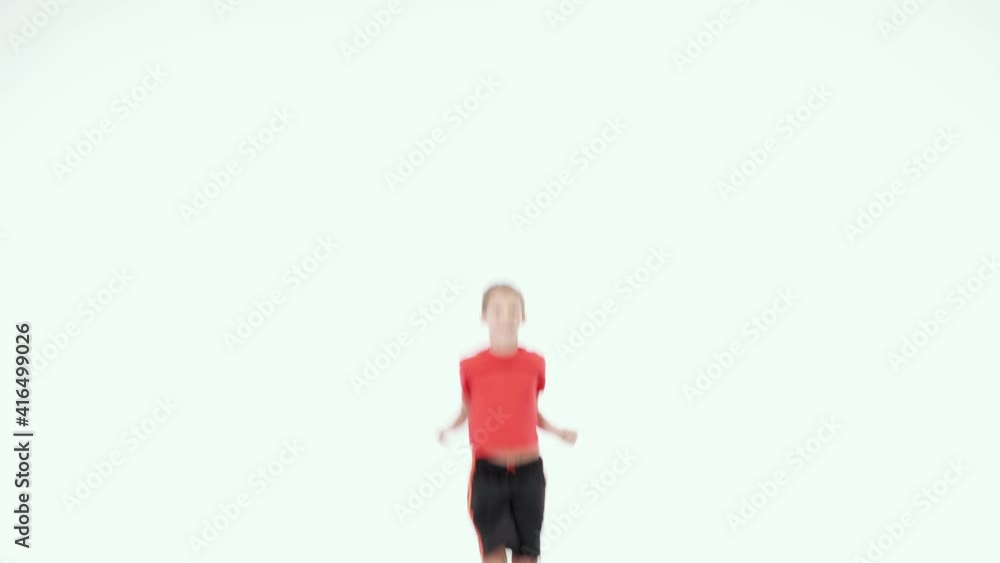 Jump for joy. Cute little elementary boy in red t shirt and black shorts smiling at camera while jumping isolated over white background Jump for joy. Cute little elementary boy in red t shirt and black shorts smiling at camera while jumping isolated over white background