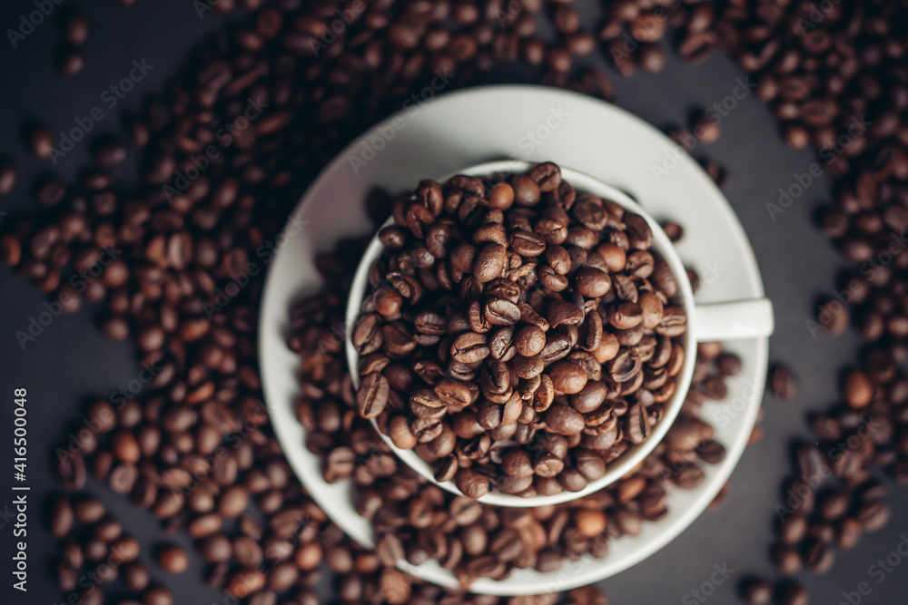 Fototapeta premium coffee beans in a cup and white saucers gray background close-up