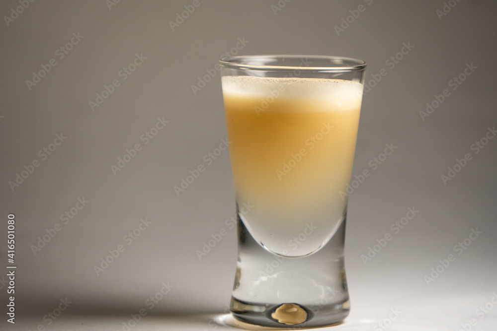 Single, isolated small shot glass with bailey's irish cream inside in studio. Single, isolated small shot glass with bailey's irish cream inside in studio.