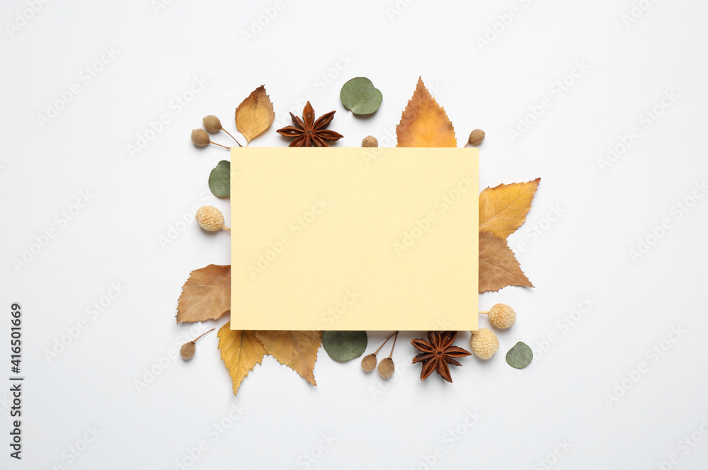 Fototapeta premium Flat lay composition with autumn leaves and blank card on white background, space for text