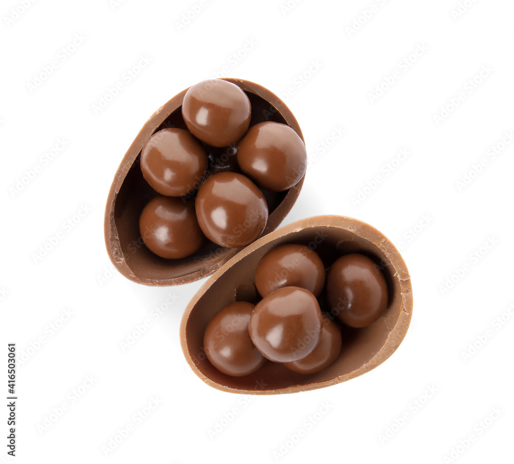 Halves of tasty chocolate egg with candies on white background, top view Halves of tasty chocolate egg with candies on white background, top view