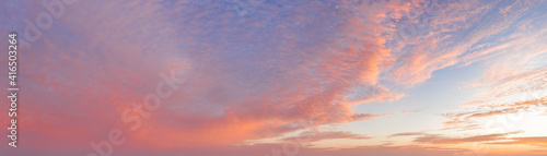 intense dramatic panoramic sunset with cirrus clouds illuminated by red sunbeams © yelantsevv